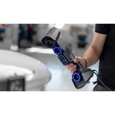 free scan trio laser 3d scanner in hand held use from front right angle view with a blurred back ground