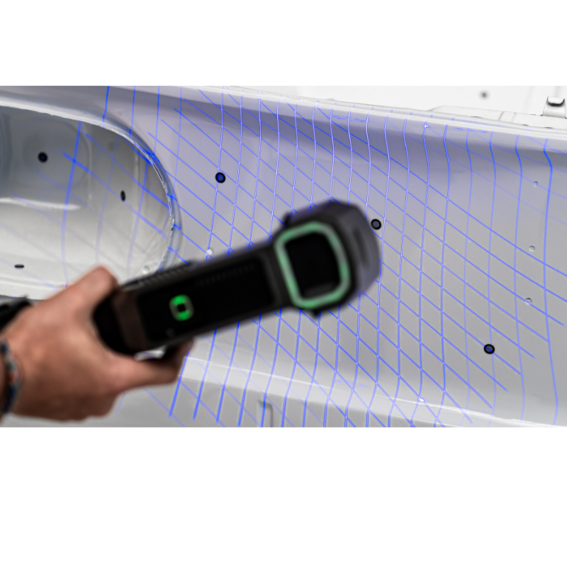 freescan trio laser 3d scanner with blue grid lines held diagonally right in front of the car