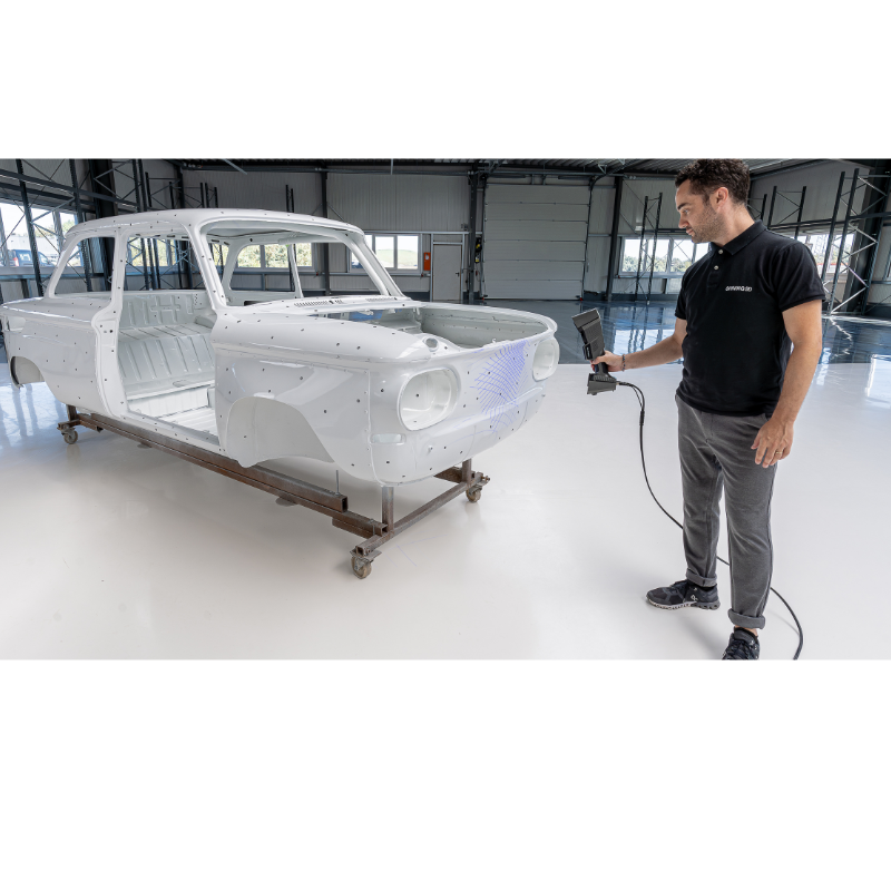 freescan trio laser 3d scanner pointed in front of white car by a man