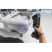free scan trio laser 3d scanner in hand held use from a rear left angle scanning a white car frame on the left