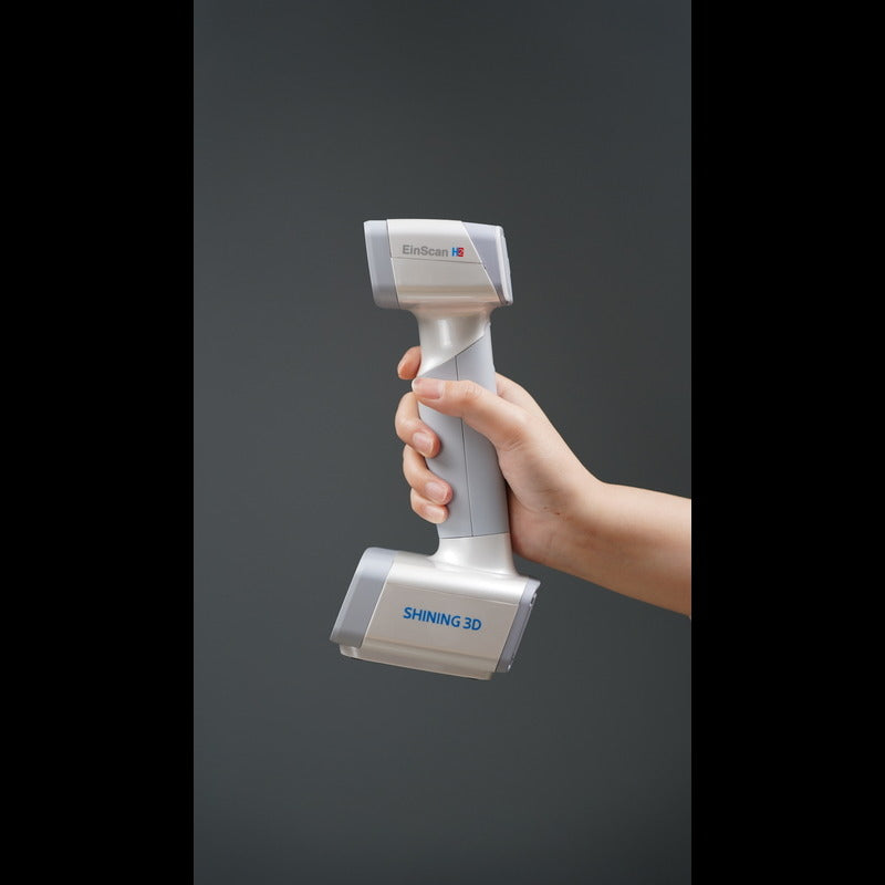 hand holding a shining 3d einscan h2 scanner from a right side view